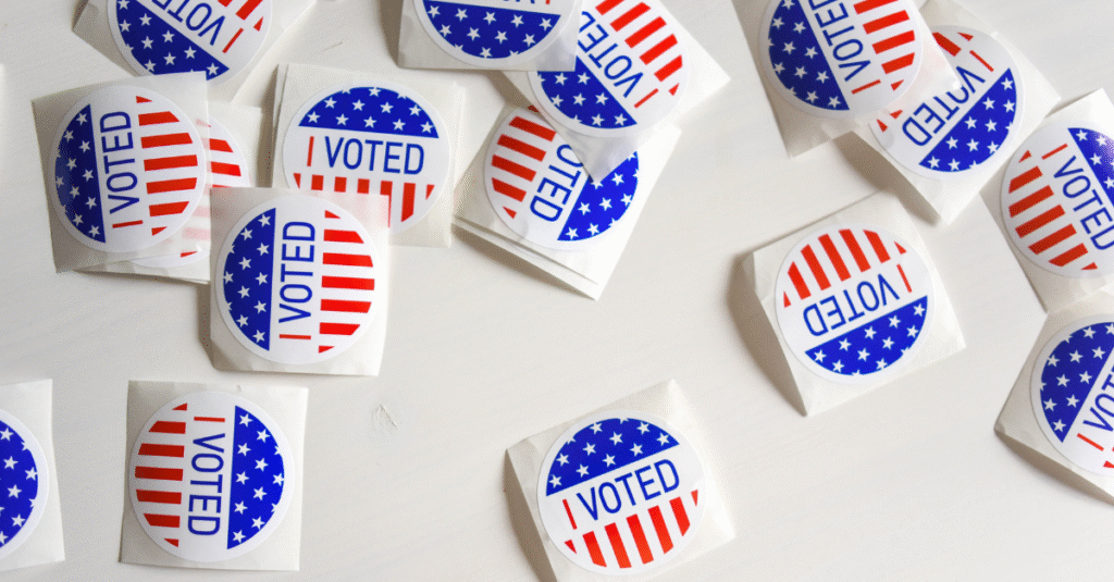 A pile of red, white, and blue "I Voted" stickers on a table
